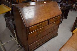 A George III oak bureau, of traditional form with fall front enclosing pigeon holes and drawers,