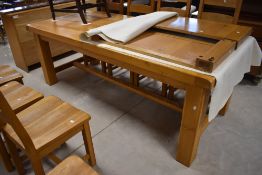 A large modern light oak extending farmhouse style refectory dining table and eight ladder-back