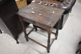 An early 20th century oak occasional table, of rectangular form, the top carved with a central