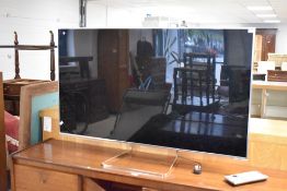 A Panasonic TX-55WT65B 55' flatscreen LED television, with power cable and two remote controls