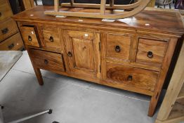A modern imported hardwood multi drawer sideboard, the rectangular top above an arrangement of six