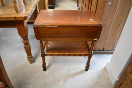 A mid-late 20th century oak drop-leaf trolley table, of traditional design with under shelf, lacking