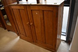 A late 19th/early 20th century pine two door cupboard, the rectangular top above two double panelled