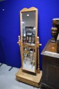 A modern pine cheval mirror, the oblong mirror plate with moulded pine frame and arched crest