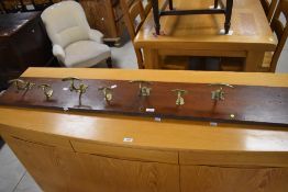 A 19th century brass and mahogany coat rack, consisting of six (three small, three larger) moulded