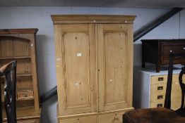 An attractive reclaimed pine press cupboard, having a moulded cornice over two arched panelled