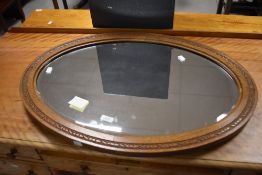 Local interest* Ernest John Oldcorn, an Arts & Crafts oak framed and bevelled mirror, of oval form
