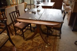 An early 20th Century Regency revival mahogany extending twin pedestal dining table of typical