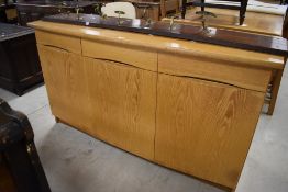 A large modern Danish made beech sideboard, the bow-fronted rectangular top above three frieze