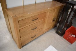 A modern light oak sideboard, the rectangular top with rounded front corners over three drawers