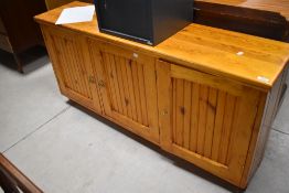 A useful modern pine cabinet, having three panelled doors, the opposing side with three frieze
