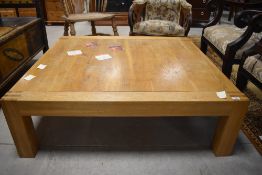 A large modern light oak low coffee table, of square form with short square section legs, 35cm x