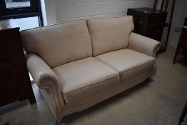 A modern upholstered two-seater settee, with cushioned back and seat within scrolled out arms 188cm