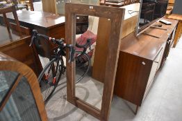A large modern stained pine wall mirror, of rectangular form 121cm x 59cm
