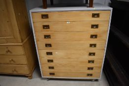 An attractive grey-painted pine multi-drawer map or plan chest, having eight pine faced slender