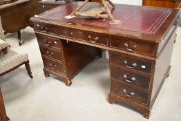 A reproduction mahogany pedestal knee-hole desk, the moulded rectangular top with inset red-