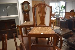 A set of six 19th century oak rush-seated dining chairs, having yoke-form top-rails over shaped