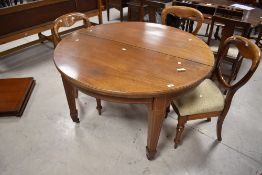 An Edwardian string-inlaid mahogany wind-out extending dining table, of circular form with inlaid
