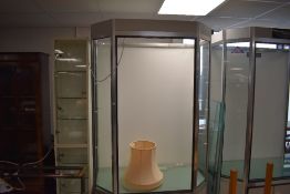 A modern aluminium, glass and grey painted board shop display cabinet, of canted rectangular form