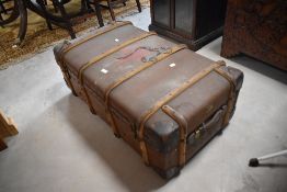 An early 20th century ribbed canvas travel trunk, with leather mounted corners, handles and