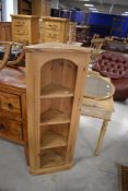 An attractive modern pine four-tier open corner display cabinet with reed moulded and canted ends,