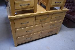 A modern light oak multi-drawer chest, the panelled rectangular top above an arrangement of seven