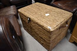 Two graduating woven fibre storage boxes, each with brass hasp and applied carrying handles to