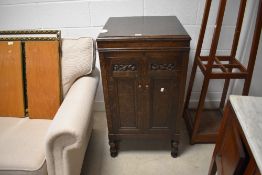 A HMV oak gramophone cabinet, of traditional form with hinged square section cover over carved and