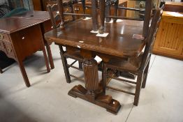 A 1940's oak draw-out dining table, the square top with rounded corners over extending draw-out ends