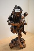 A large 20th-century Chinese hardwood figure of an Immortal, featuring a bearded, elderly man in