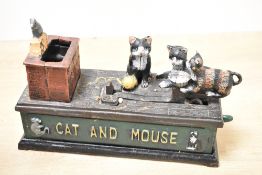 A vintage cast iron 'Cat and Mouse' mechanical coin bank, depicting a playful, hand-painted cat