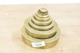 A set of eight cast brass graduating/nesting weights, 1/2 Oz - 4lb, one weight (1oz) possibly
