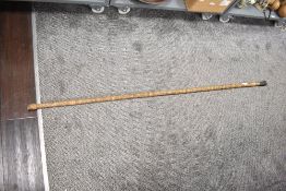 A tall 20th-century carved bamboo staff, decorated with blackened incised figural and geometric