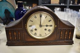 A 1940's oak arched mantel clock, with bead and spindled moulding and Roman hours, the striking
