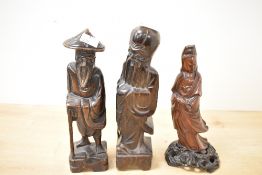 Three 20th-century Chinese carved hardwood figures, most likely of immortals, each dressed in