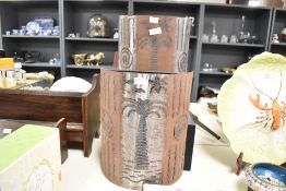 Two late 20th-century recycled metal wall lamp shades, featuring decorative palm trees and swirl-