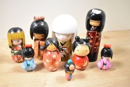 A quantity of late 20tth-century wooden Japanese Kokeshi dolls, featuring hand carved floral and