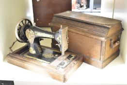 A presumed early 20th-century Singer sewing machine, featuring a hand crank mechanism with