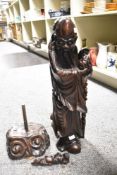 A large Carved Chinese hardwood immortal Shou Hsing, modelled holding a staff and looking to one