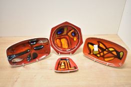 Four mid 20th-century Poole Pottery 'Delphis' dishes and pin trays, featuring vibrant abstract