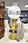 An early 20th-century Victorian-style brass oil lamp, featuring an etched glass globe shade with a