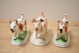 Three late 19th-century Staffordshire pottery cow creamers, all featuring red and white hide