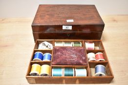 An early 19th-century mahogany sewing box, filled with vintage sewing notions; sold with a wooden