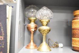Two late 19th to early 20th-century oil lamps, to feature a converted brass example with a crystal