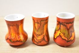 Three small mid 20th-century Poole Pottery bud vases, to include two 'Delphis' examples and one '