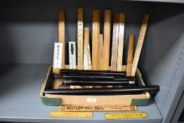 A large selection of 20th-century wooden rulers and advertising yardsticks, to include a variety