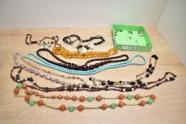 A collection of beaded necklaces including circular amber beads cherry amber imitation beads (58