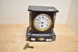 A Victorian black slate and marble mantel clock, of architectural style, having twin columns upon