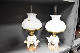 A fine pair of late 19th-century German Sitzendorf porcelain oil lamps, one features three