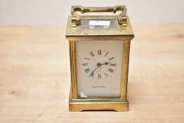 A small early 20th-century Mappin and Webb brass carriage clock, having a white enamel dial of Roman